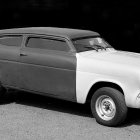 Vintage White Car with Elongated Body and Golden Rims on Black Background