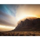 Stormy landscape with lightning near rocky cliff at sunset