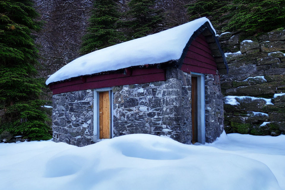 Stone cabin with red roof in snowy forest setting