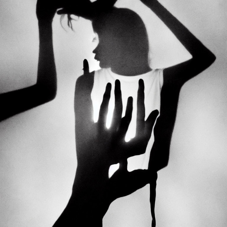 Monochrome image of silhouetted figure with dramatic shadows