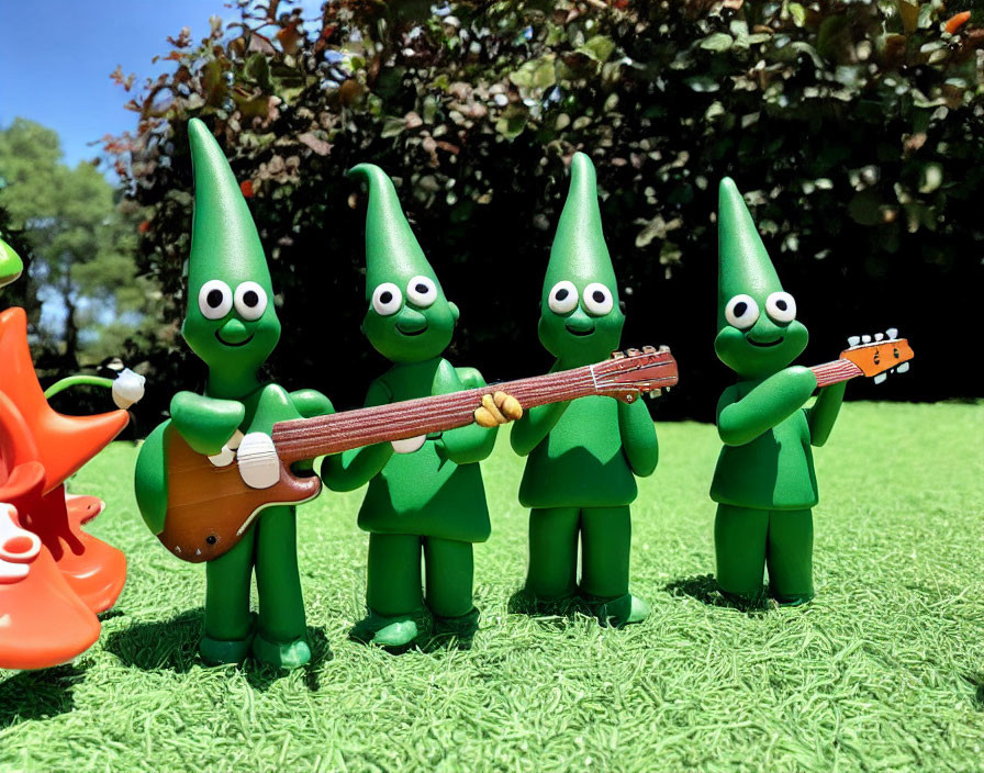 Four Elf-like Toy Figures Playing on Grass with Guitar