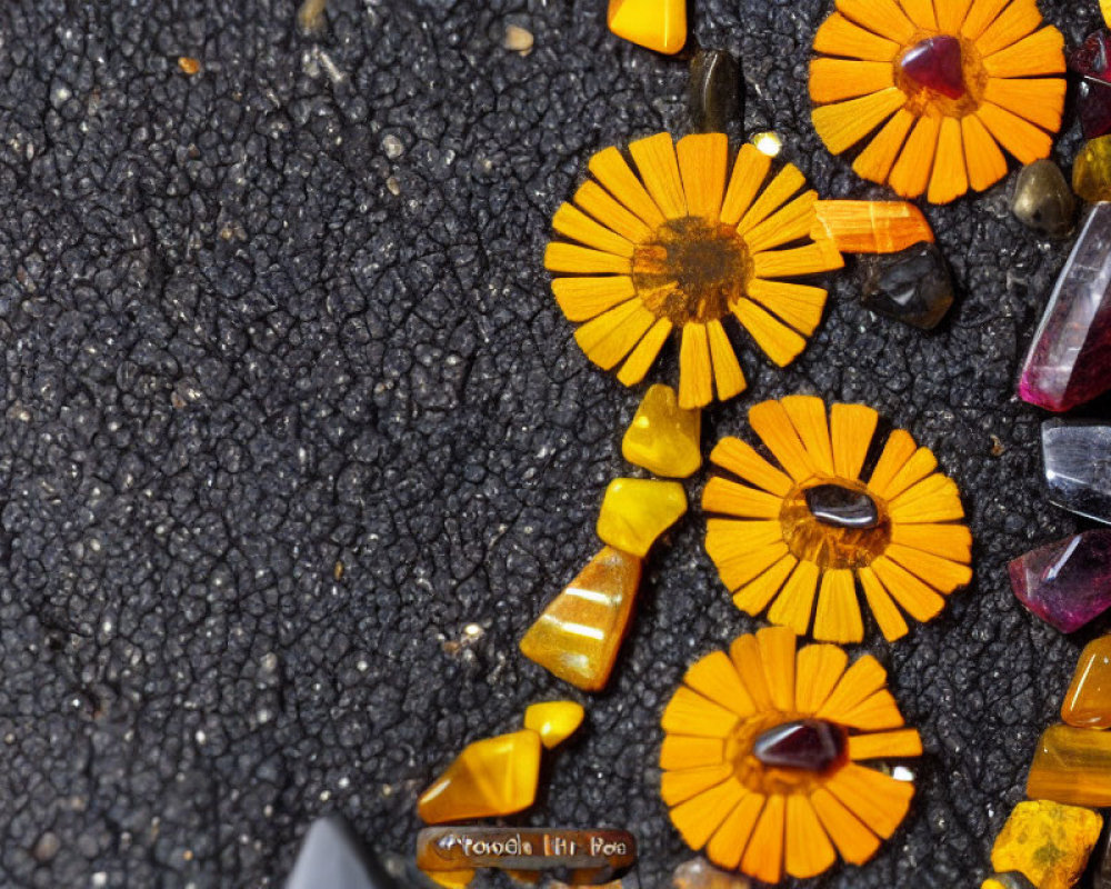 Orange Marigold Petals and Colorful Crystals on Black Surface