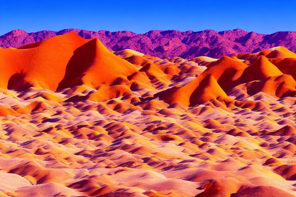 Orange Sand Dunes Against Blue Sky and Purple Mountains