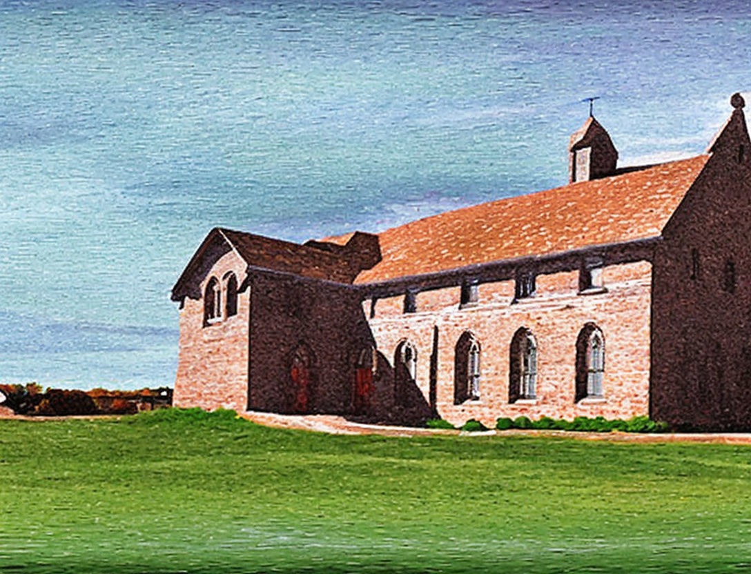 Old brick church with arched door and windows against blue sky and green grass