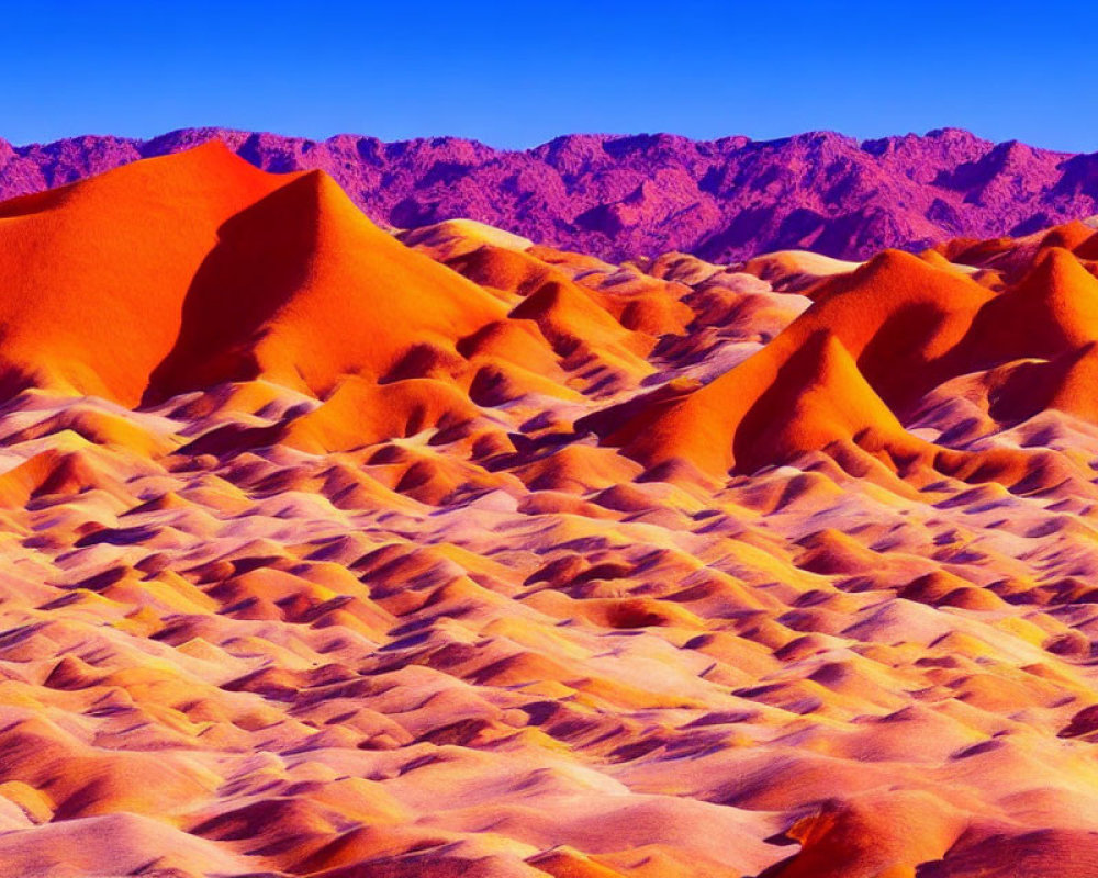 Orange Sand Dunes Against Blue Sky and Purple Mountains