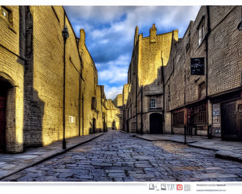 Historical cobblestone street and old brick buildings under clear blue sky