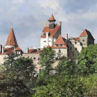 Castle with Multiple Spires and Red Roofs on Green Hill