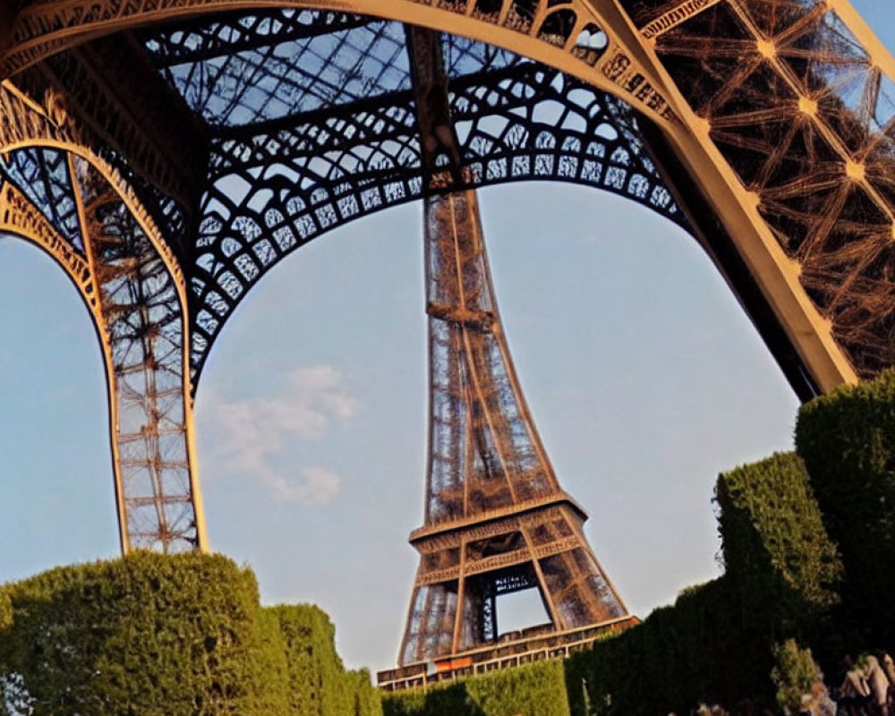 Eiffel Tower's intricate metalwork from below with visitors against dusky sky