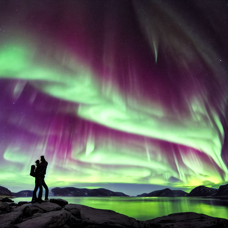 Couple Embracing Under Northern Lights by Lake & Mountains