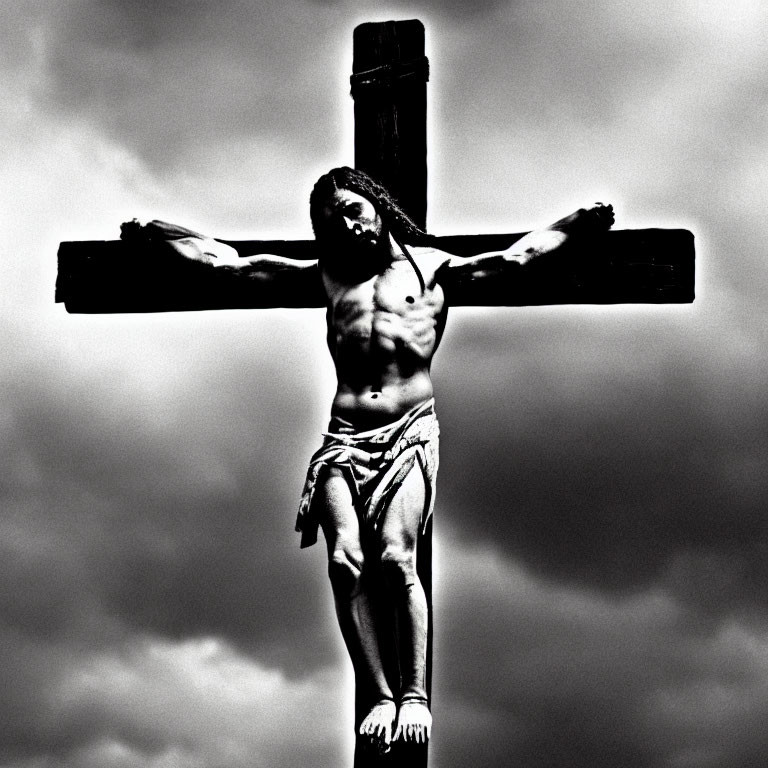 Monochrome sculpture of man on cross under cloudy sky