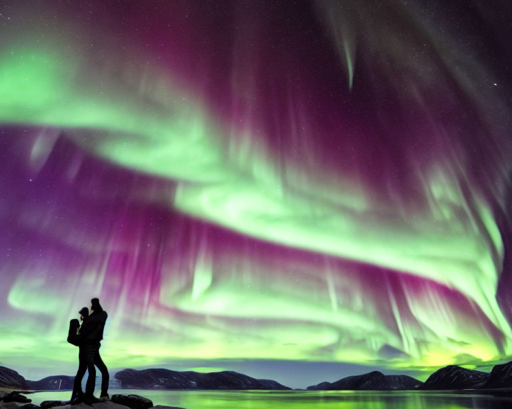 Couple Embracing Under Northern Lights by Lake & Mountains