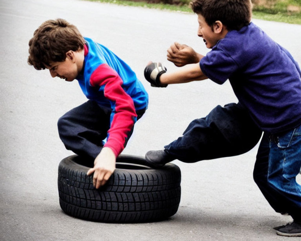 Boys playing with tire on paved surface