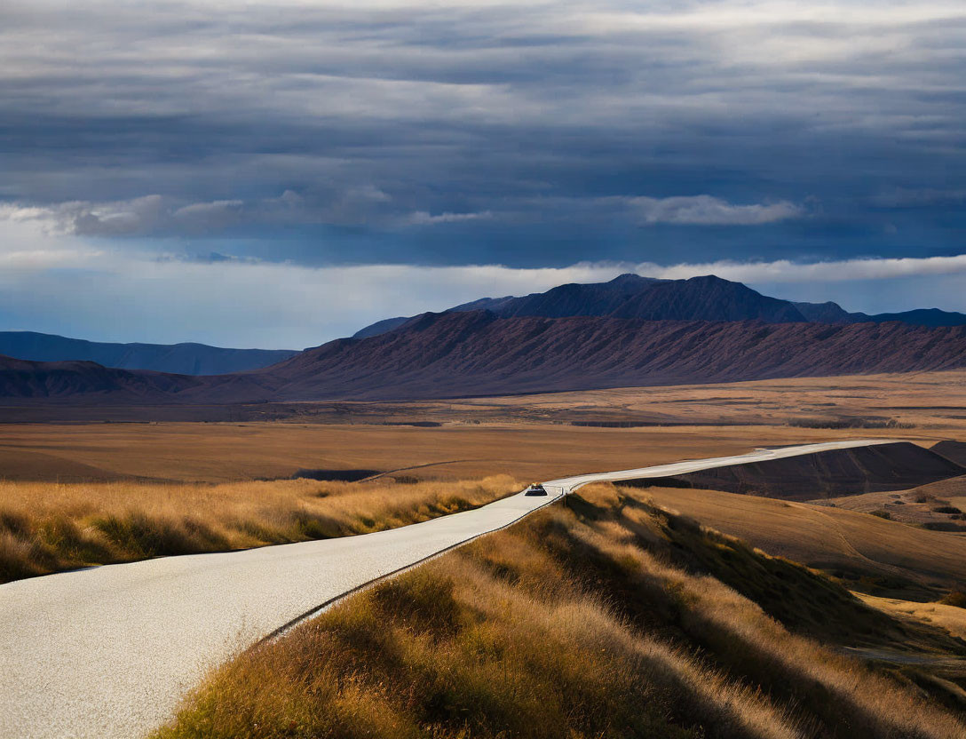 Scenic winding road through golden grass landscape