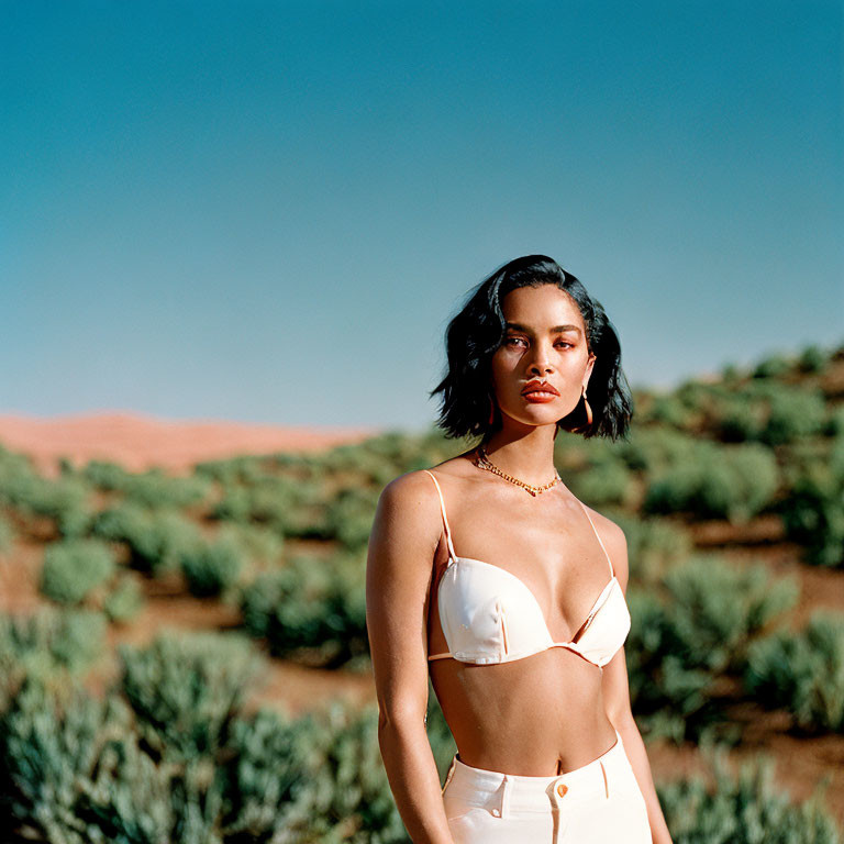 Person in white outfit in desert with blue sky and red sand dunes