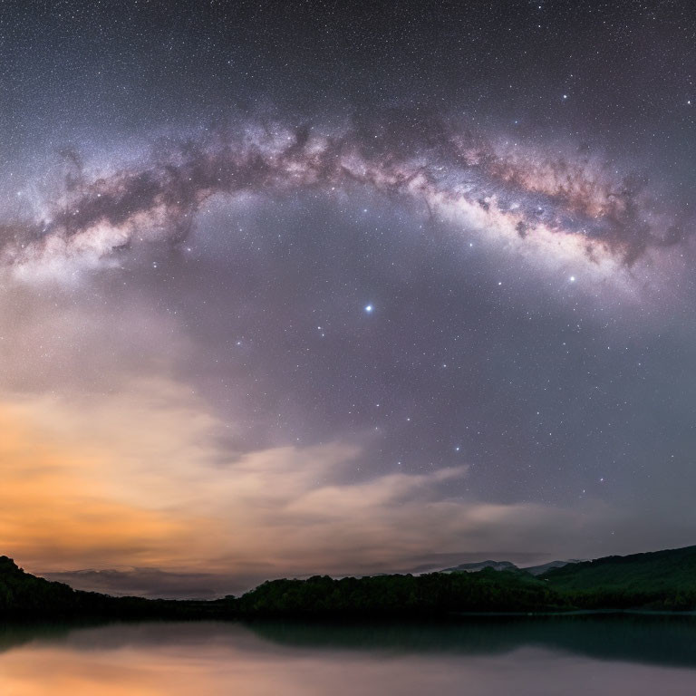 Panoramic Milky Way over tranquil lake at sunset