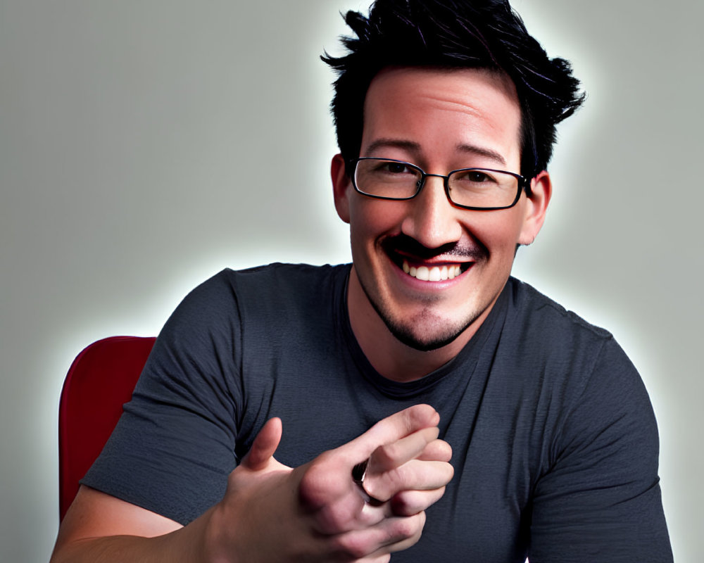 Smiling man in gray t-shirt gesturing on light background