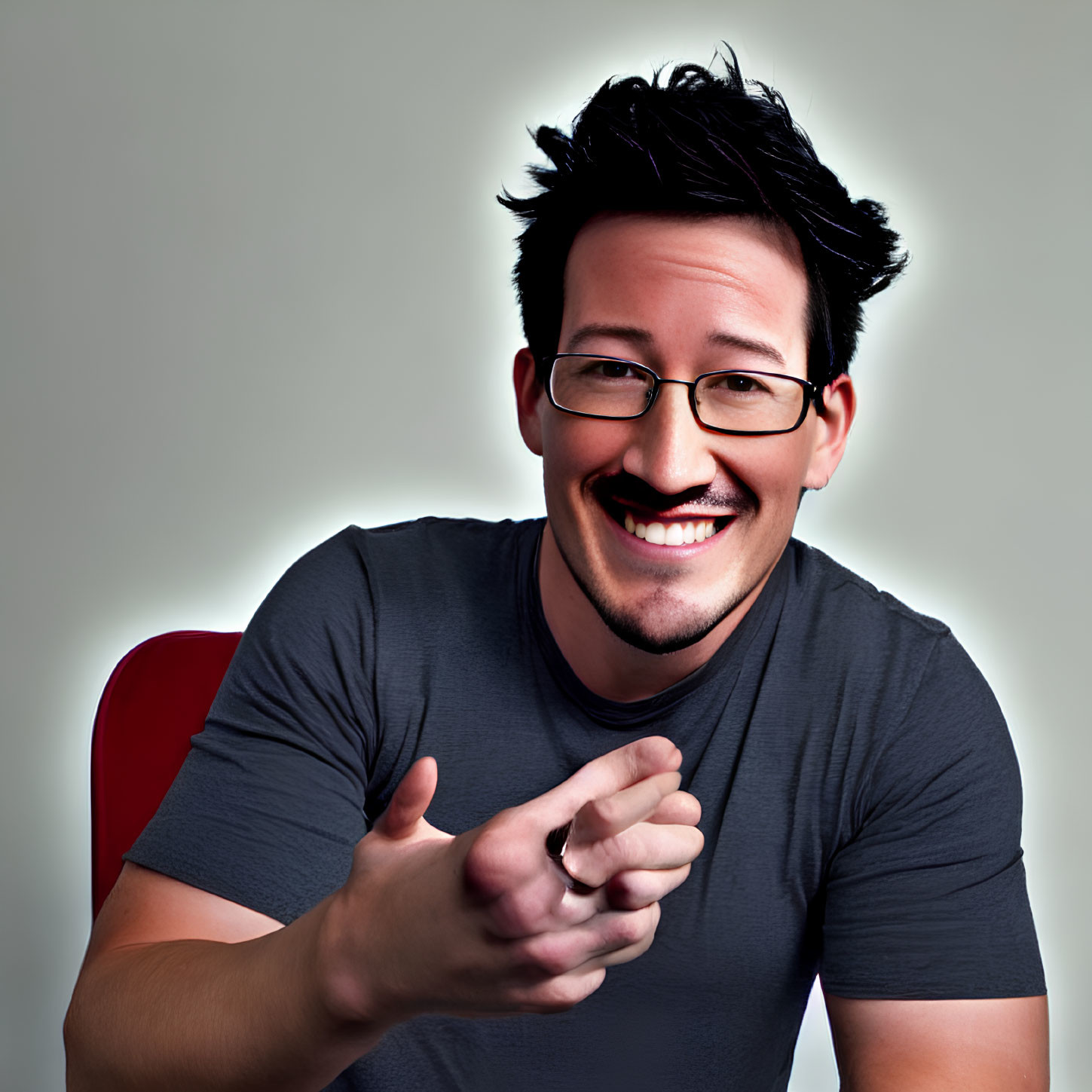 Smiling man in gray t-shirt gesturing on light background