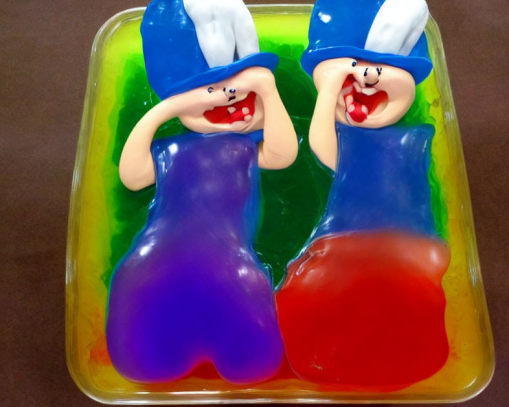 Cartoonish figures in blue hats and cloaks in colorful gelatin dessert