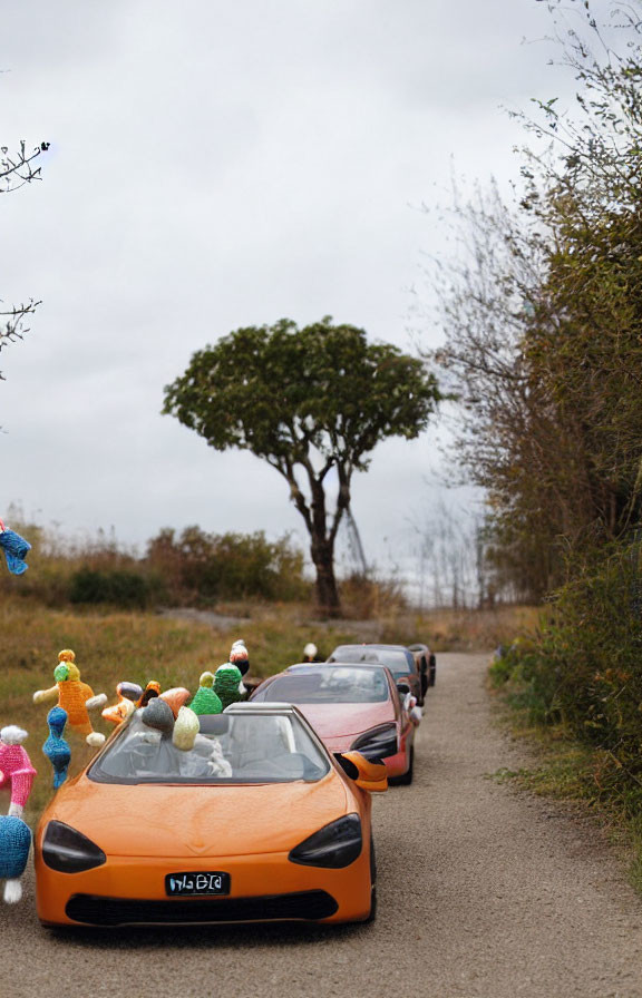 Colorful Knitted Toy Ducks Lead to Parked Orange McLaren on Rural Road