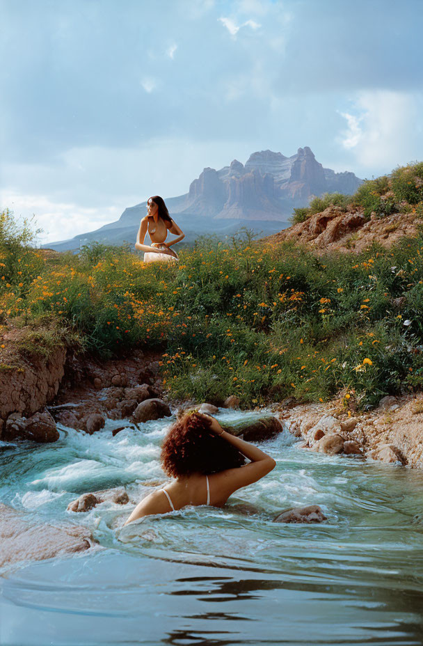 Individuals relaxing by river and mountain in natural setting