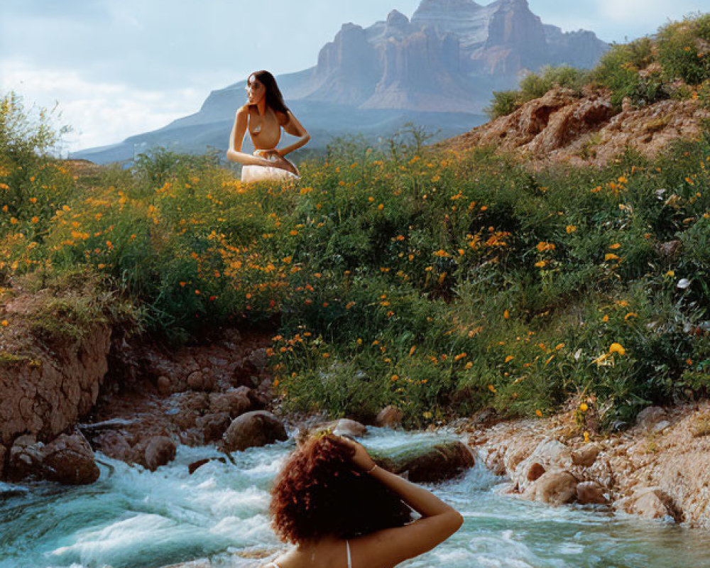 Individuals relaxing by river and mountain in natural setting