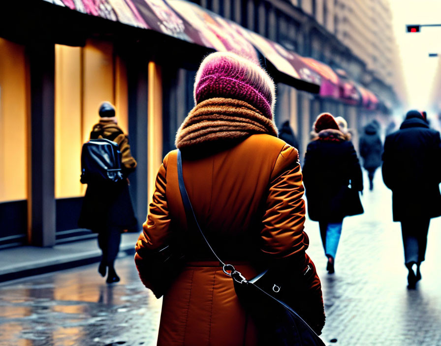 Person in yellow coat and pink hat walks in foggy city street