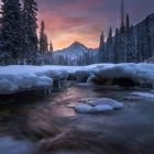 Snow-covered trees and frozen river in serene twilight winter landscape