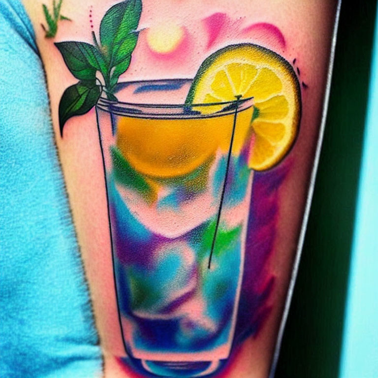 Vibrant cocktail glass tattoo with lemon slice and mint leaves on forearm