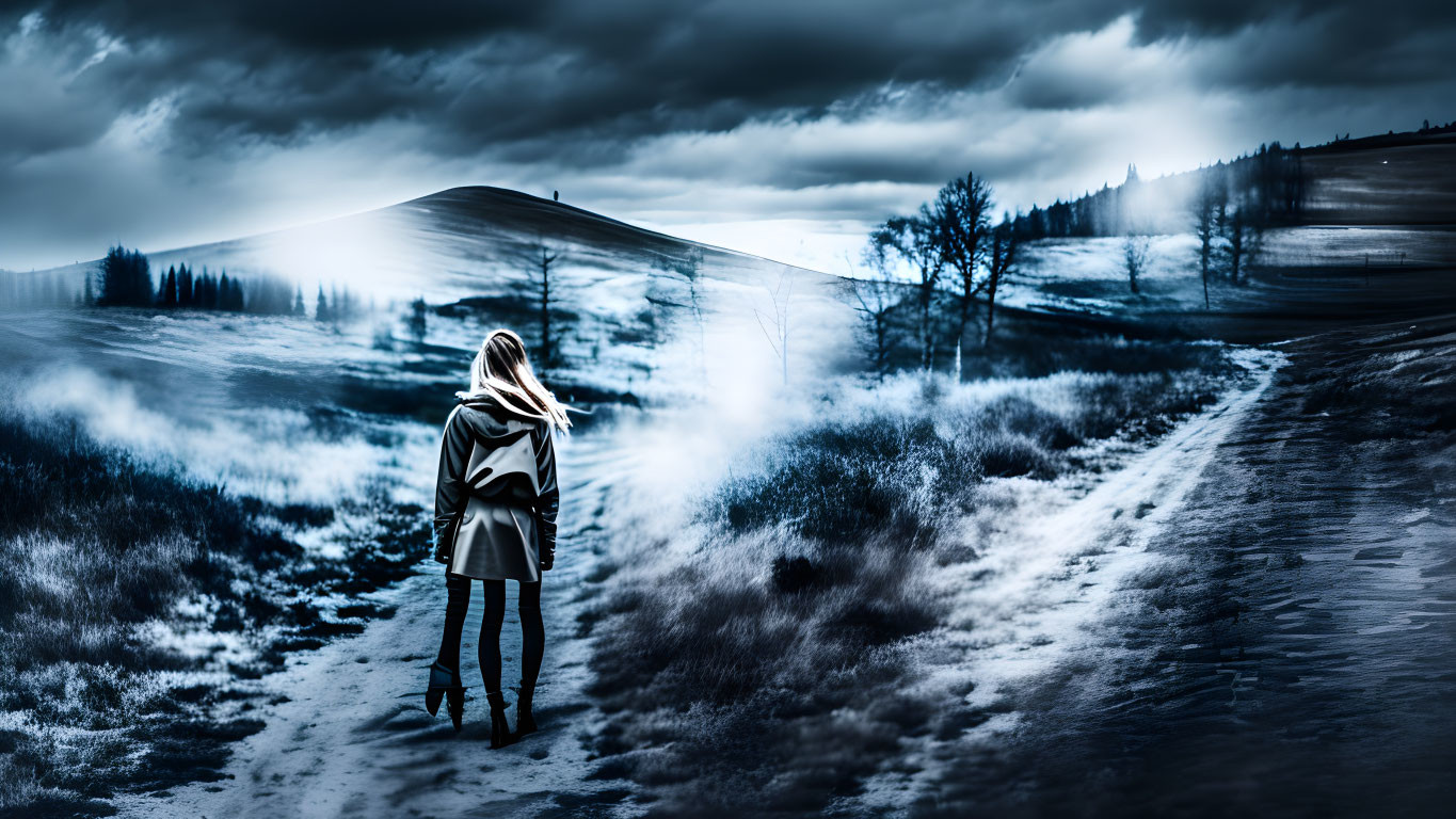 Woman standing on path in surreal blue landscape with mist and bare trees.