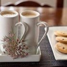 Realistic still-life artwork: three coffee cups, cookies, and beans