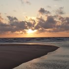 Scenic painting of ocean sunset with rolling waves and cloudy sky