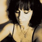 Sepia-toned portrait of woman with curly hair and butterfly detail