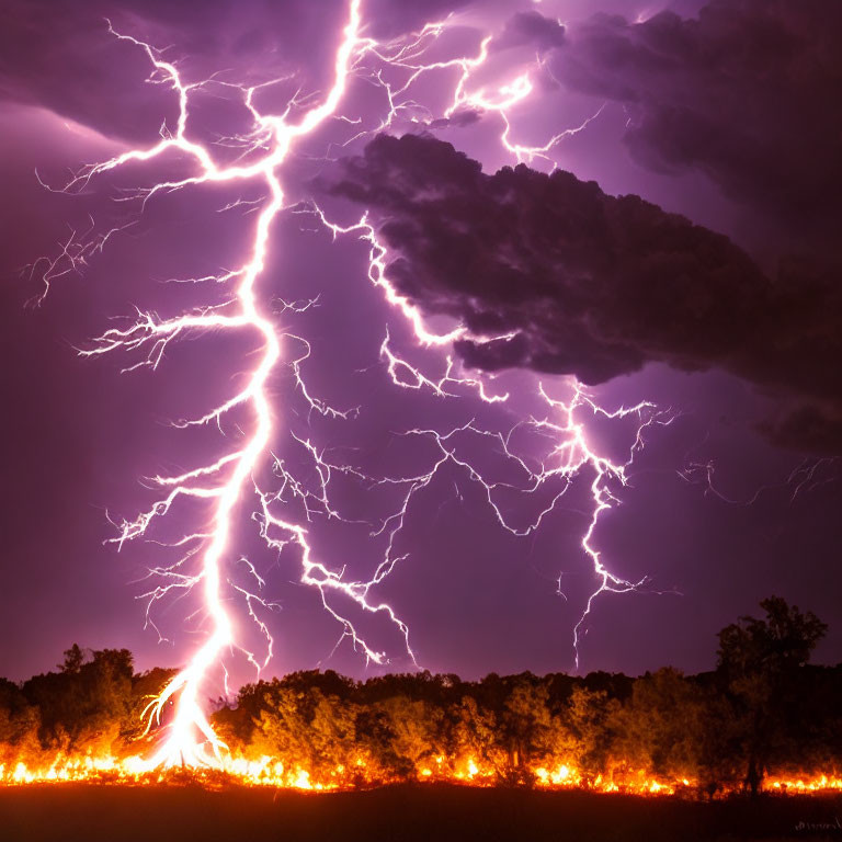 Dramatic lightning strike over glowing fire in night sky