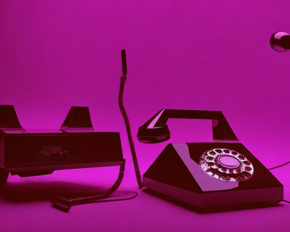 Retro telephone and answering machine under magenta light