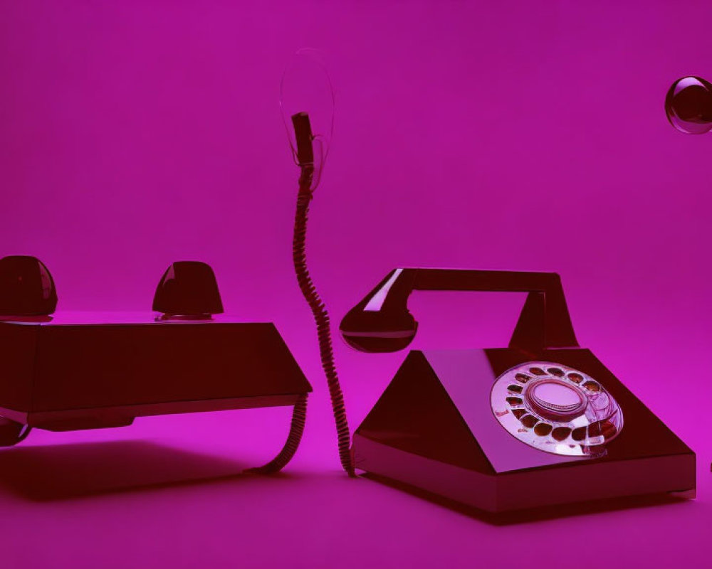 Vintage rotary phones connected under pink-purple lighting with lamppost and hat.