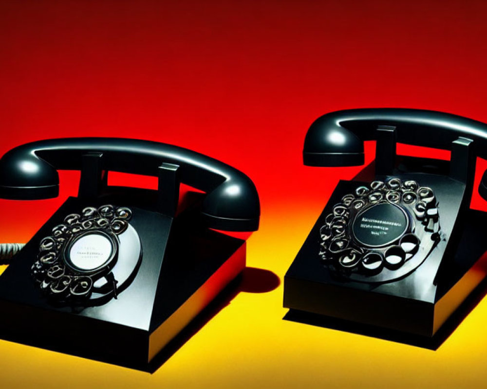 Vintage rotary dial telephones on red to yellow gradient background