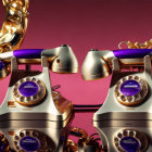 Vintage gold and purple telephones on pink surface with golden chains