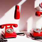 Vintage red rotary dial telephones on pink and white background