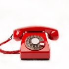 Vintage Red Rotary Dial Telephone on White Background