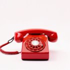 Vintage Red Rotary Phone Off Hook on White Background