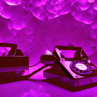 Vintage phones and radio under purple light on textured backdrop