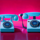 Vintage pink and blue rotary dial telephones on red gradient background