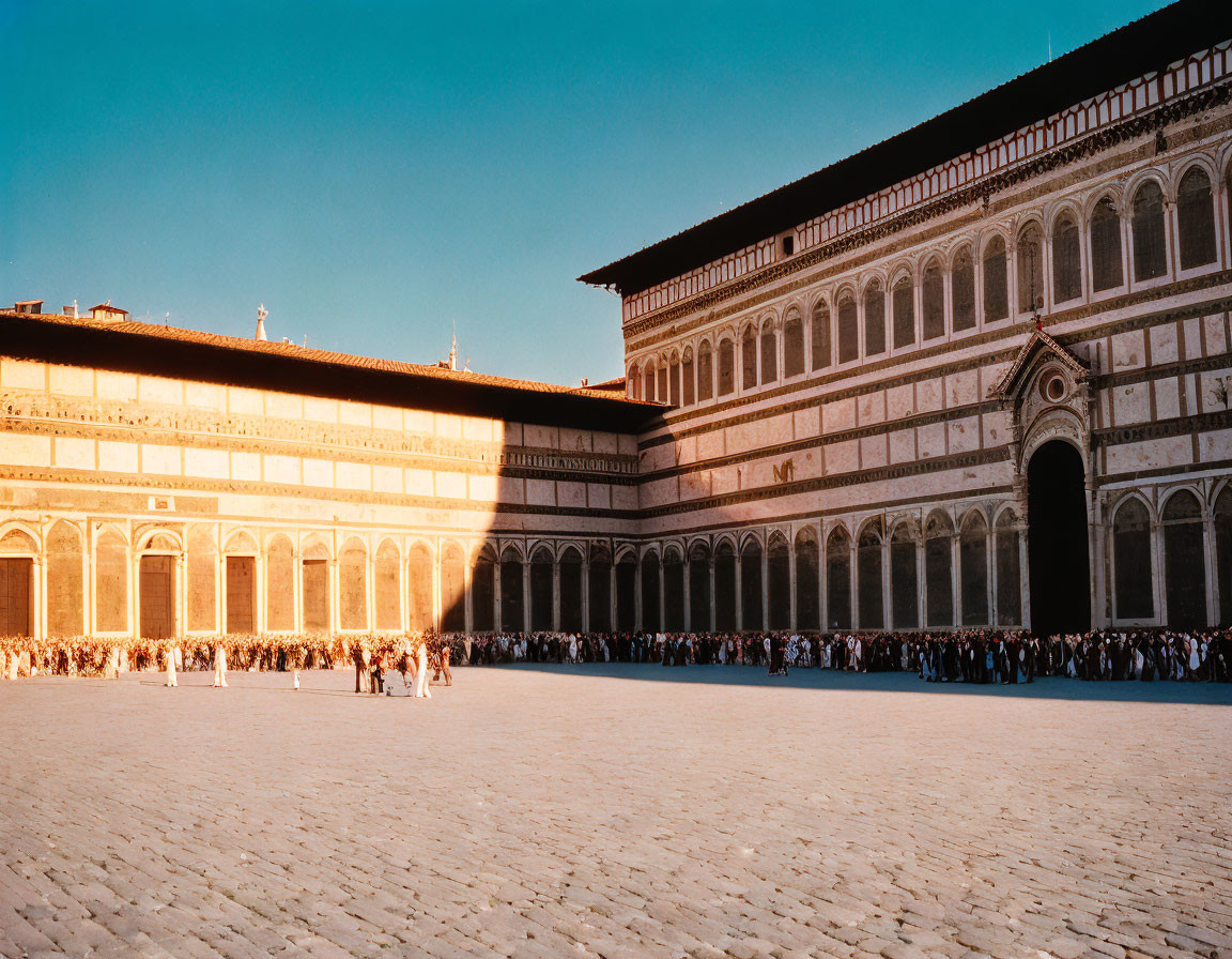 Renaissance architecture courtyard at sunset with people in line