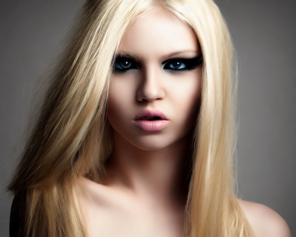 Blonde person with smoky eye makeup on gray background