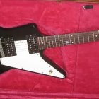 Vintage black and white electric guitar on crimson textured background