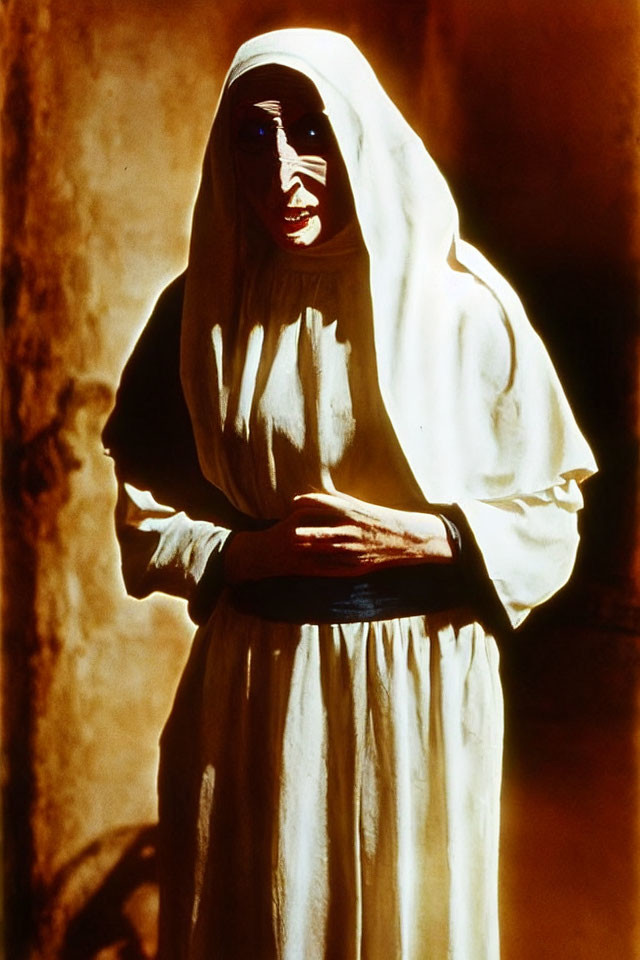 Person in White Robes with Hood in Warm Light, Expressing Concern