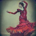 Stylized image of woman in red flamenco dress with fan and sparkling background