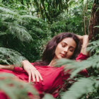 Woman in Red Dress Resting Among Lush Green Foliage