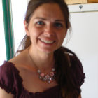 Serene young woman with dark hair and striking eyebrows in burgundy garment