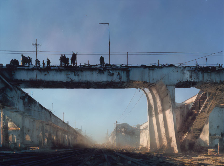 Silhouetted figures on damaged concrete bridge with collapsed sections.